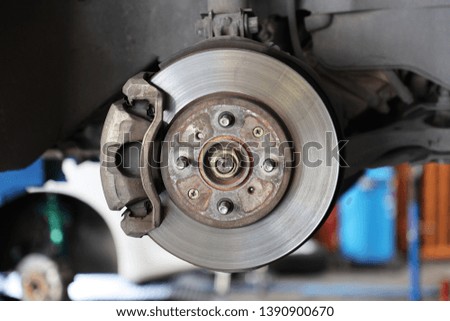 maintaining car brake disc at repair service station. 