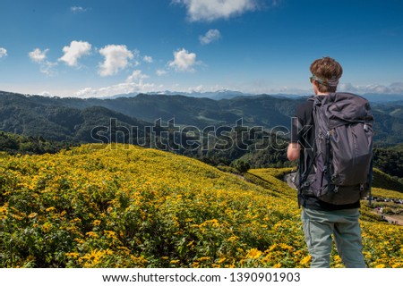 Travel man standing on mountain and  taking picture by digital camera.