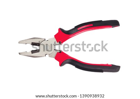 One new metal pliers with rubber handles black and red color isolated on white background. Top view. Repair or building concept Royalty-Free Stock Photo #1390938932