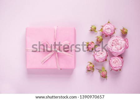 Pink gift. The concept of the holiday, women's day, mother's day, birthday. Present with flowers. Gift cart. Selective focus.