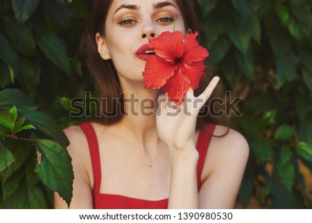 beautiful woman with make-up on face red lips green shrub rest nature