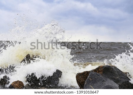 the waves beat against the rocks on the sea shore creating splashes. seascape