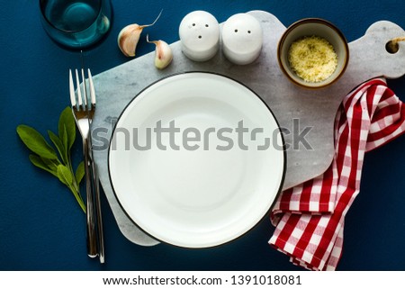 empty served plate on marble serving board and blue spice background