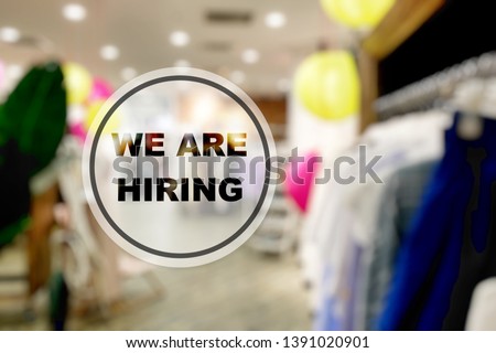 'We are hiring' notice outside a retail store front which is looking to add or recruit more employee or staff. Concept for a strong labor market or booming economy leading to a surge in job creation.