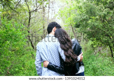 Back view of loving couple is standing in garden and  hugging- Image Royalty-Free Stock Photo #1391024012
