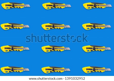 Horizontal rows of stationery knives with yellow and black plastic handle on blue background. Seamless pattern