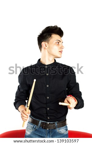 Portrait of a drummer playing with drum stick wearing black in studio