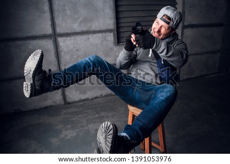 A man is a photographer with camera. Funny Face. Dark gray background. Place for text. The photographer shoots at the camera. Picture of the camera. Profession