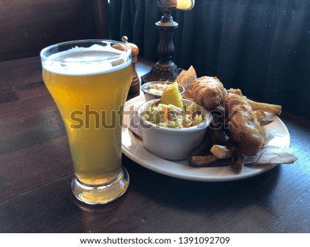 Draft beer in a glass with fish and chips