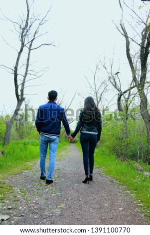 Couple walking in the spring garden, holding their hands. Love concept. Engagement photo session - Image Royalty-Free Stock Photo #1391100770