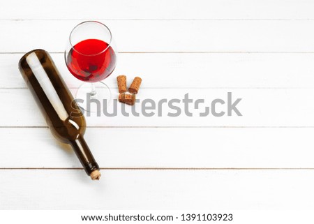 Goblet of red wine on wooden table on wooden wall background