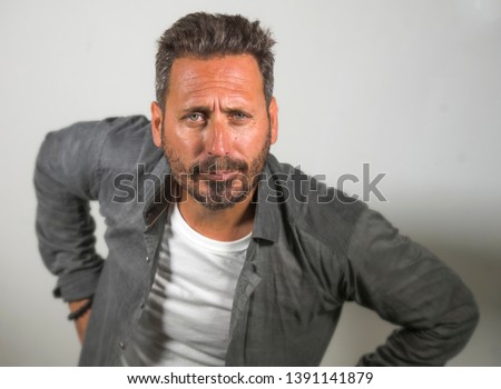 isolated portrait of young happy and handsome 40s man with blue eyes and beard  in casual shirt posing in cool attitude smiling cheerful and confident on studio background 
