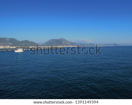 Beautiful view from the boat on the city of Alanya, Turkey. Blue serene Mediterranean sea on a clear warm summer day.