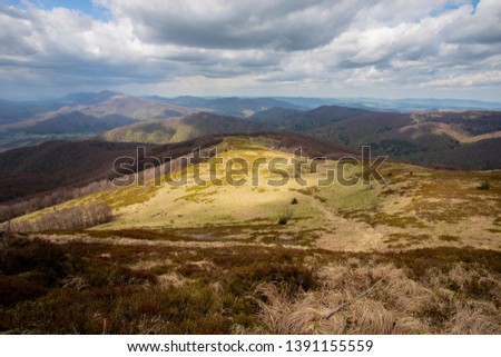landscape of mountain peaks under the sun and blue sky and white clouds in the Bieszczady Mountains