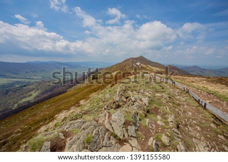 landscape of mountain peaks under the sun and blue sky and white clouds in the Bieszczady Mountains