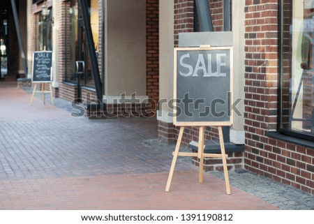 street chalkboard sign display with text sale near shop outdoor.