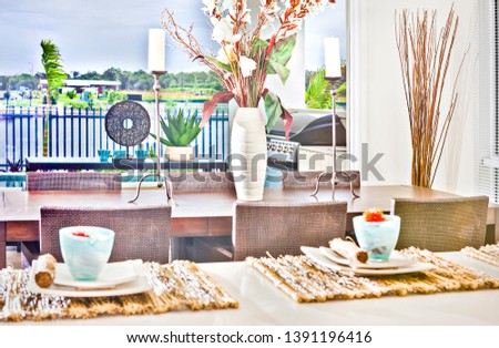 Beautiful natural flower vase with ceramic items on kitchen table, river also forest can see behind fence, colorful photograph from lightning, daytime scene.