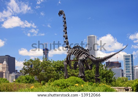 Sculpture of an extinct dinosaur looking at the new construction of downtown Chicago
