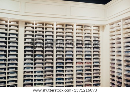 Shelves with a lot of Men's shirts neatly folded in the retail store clothes and business suits.