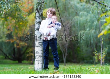 Brother and baby sister walking in a park