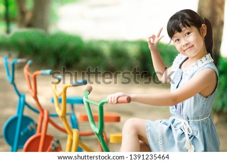 Fun and cheerful concept. little asian girl smiling happy at summer playground - photo