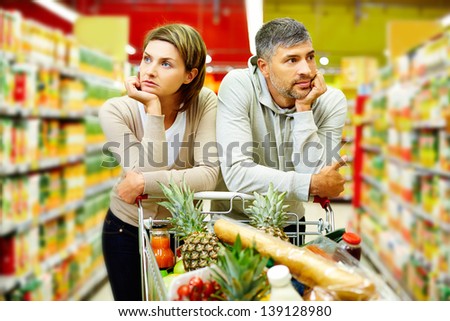 Image of young couple with cart in supermarket Royalty-Free Stock Photo #139128980