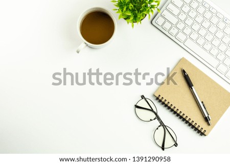 modern white office desk with a computer keyboard, pen, notebook and cup of coffee. - top view with copy space