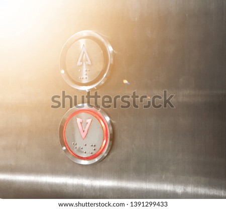 Inside the metal elevator down buttons reflected sun light. Image may contain soft focus.