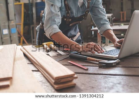 Carpenter working with equipment on wooden table in carpentry shop. woman works in a carpentry shop. Royalty-Free Stock Photo #1391304212