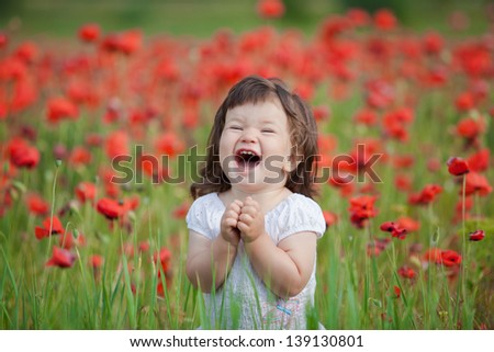 very happy child girl in poppy field