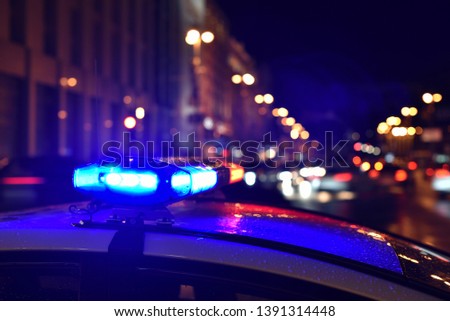 Police car in night city traffic jam in storm