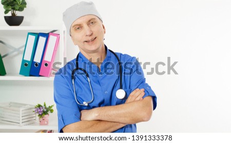 Portrait Of A Confident Mature Doctor Looking At Camera Isolated On Medical Office Background.