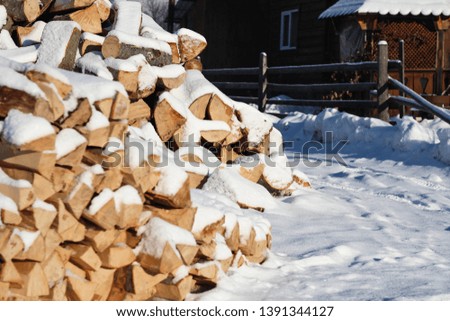 Firewood. Fresh morning in the snowy mountains at a ski resort. Snow-covered wooden houses