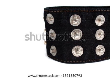 Macro picture of black jeans belt with many buttons isolated on a white background, copy space. Rock music, alternative punk fashion.