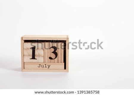 Wooden calendar July 13 on a white background close up