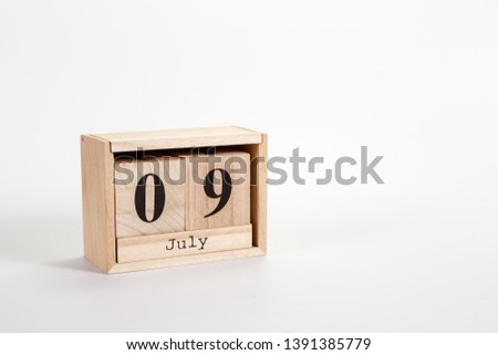 Wooden calendar July 09 on a white background close up