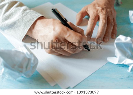 A pen in a man's hand. White sheet of paper. Signing a document.