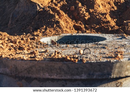 Construction site concrete well for water pipes and sewage Close up Royalty-Free Stock Photo #1391393672