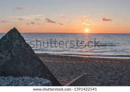 Very beautiful sunset on the Baltic Sea. The sea is calm. In the foreground of the breakwater pyramid.