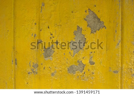 The background of the old yellow cement wall surface is peeling off.