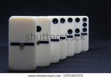 White marble dominoes on a black color background.