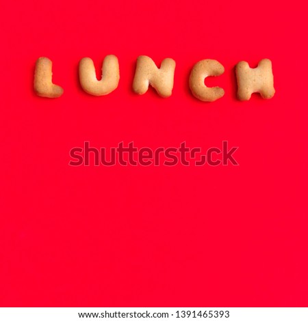 The Letter Word Lunch. Alphabet Cookie Cracker on red background paper texture. Red empty backgrounds. Top view, copy space, flat lay.