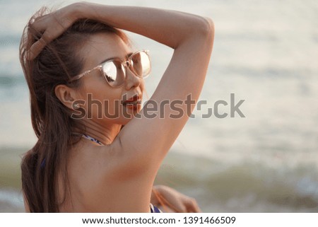 young beautiful​ girl​ in​ a​ bathing​ suit​ and​ background​ of​ the​ sea, the​ concept​ of​ vacation, vacation, summer, travel 