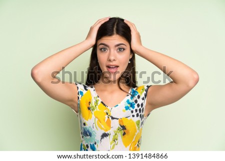 Teenager girl with floral dress with surprise facial expression