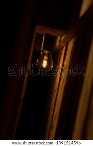 A bulb englightens dark and wooden interior