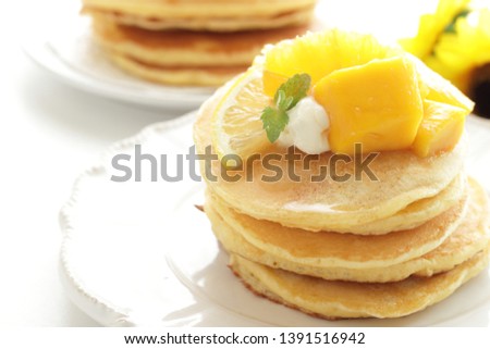 Sliced orange and Mango on homemade pancake for breakfast image
