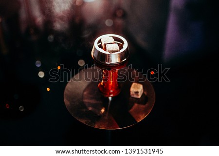 Process of making hookah for smoking. concept of smoking a hookah and having a good time. hookah bowl on the dark background of the bar close up view. Toned image Royalty-Free Stock Photo #1391531945