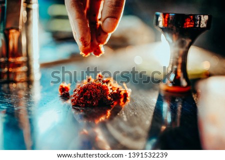 Process of making hookah for smoking. concept of smoking a hookah and having a good time. laying tobacco in a hookah bowl close. Toned image Royalty-Free Stock Photo #1391532239