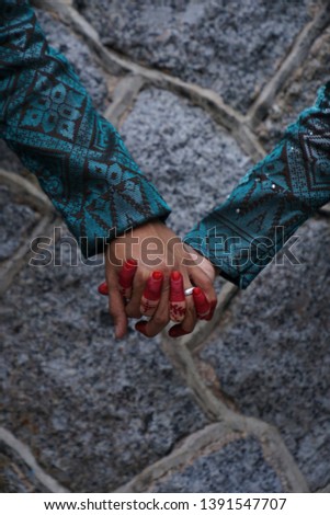 Close-up of groom wear silver ring holding his wife hand with texture background. Asian married couple holding hands. Love & bonding. 