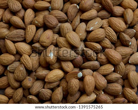 Wooden board and organic almonds, nuts 
